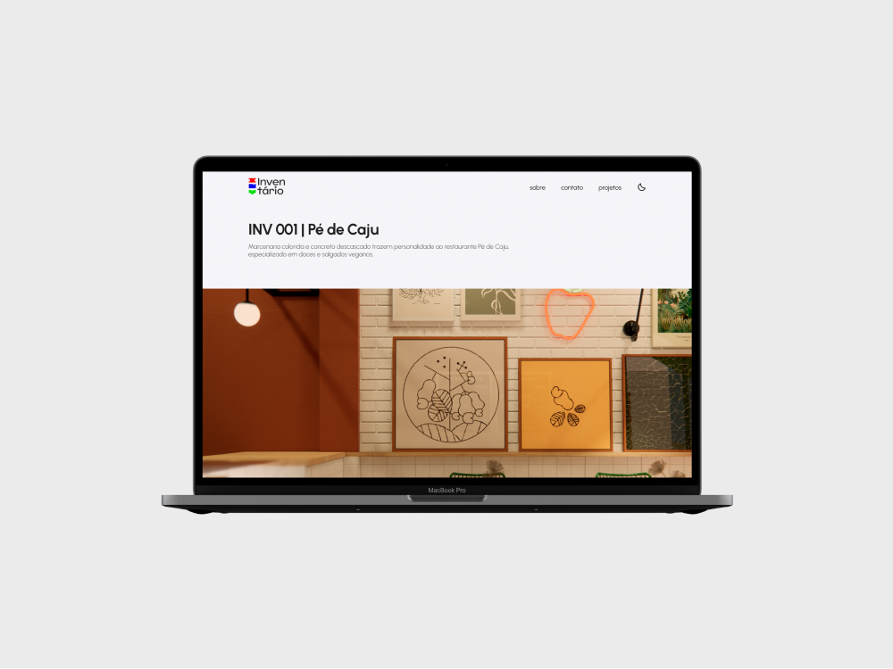 A página individual do projeto INV 001 aberta em um MacBook Pro. O computador está voltado para frente e flutua em um fundo branco acinzentado.
